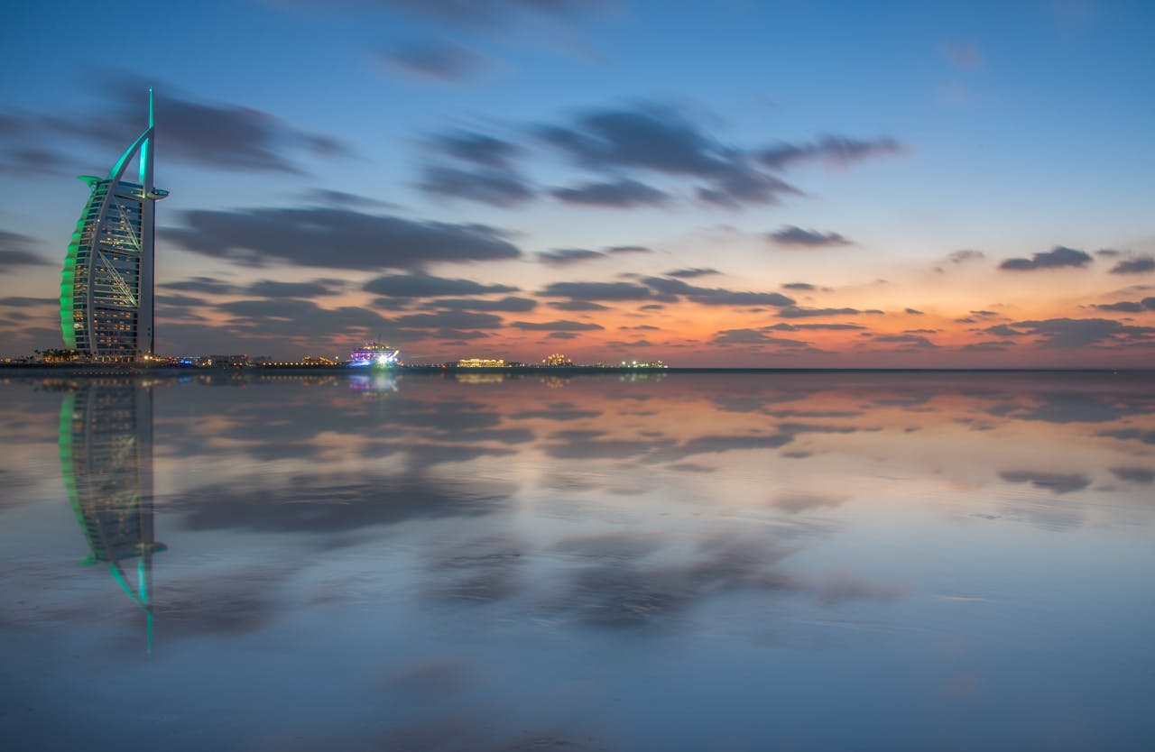 Scenic view of Burj Al Arab with stunning dusk reflections in Dubai's calm sea.